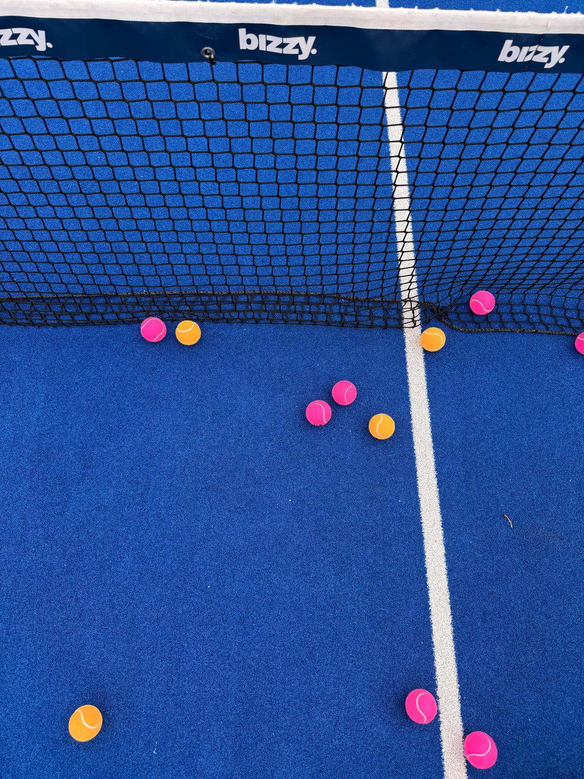 gekleurde padelballen in het net